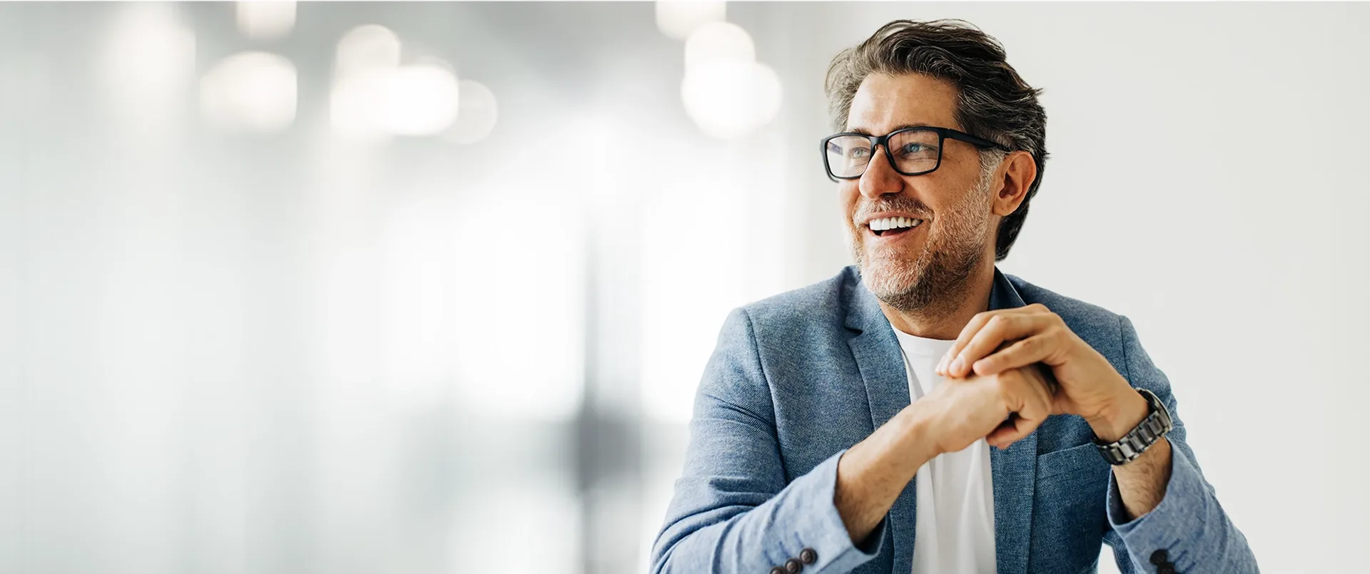 Smiling and confident business leader in a bright professional environment.