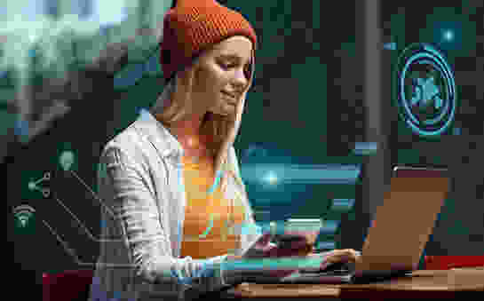 High-tech girl on computer holding cellphone