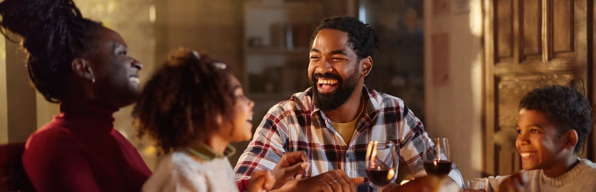 Happy African descendant family celebrating Thanksgiving together at home.