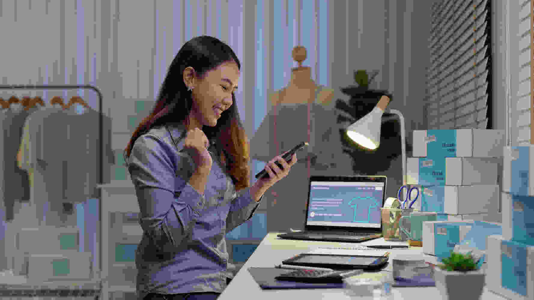 Saleswoman celebrating on cellphone