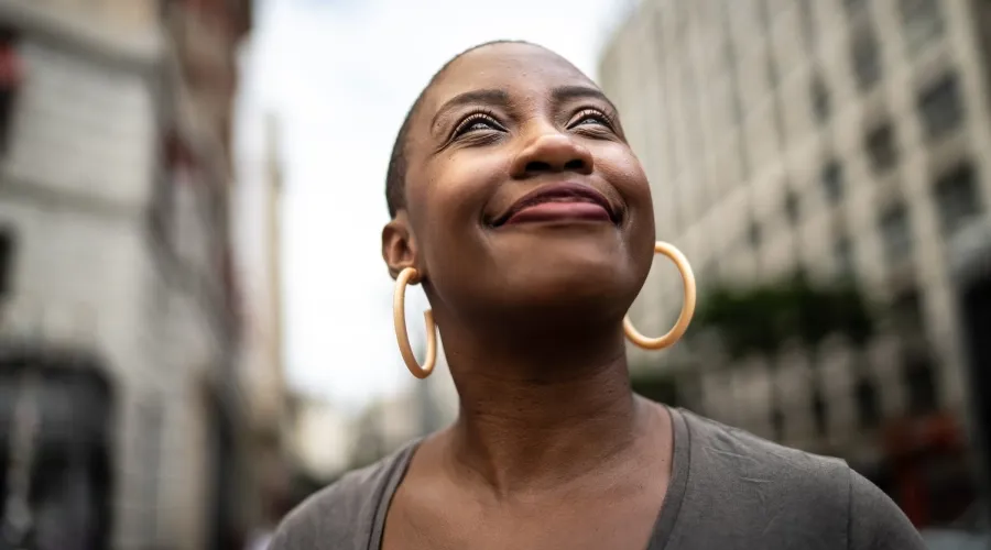 Black woman looking upward with a confident and hopeful expression.
