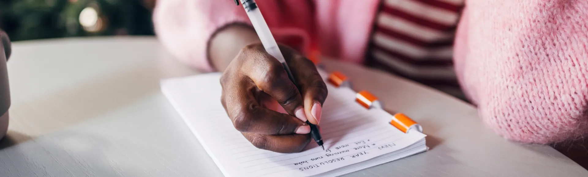 Handwritten New Year resolutions on a notebook.